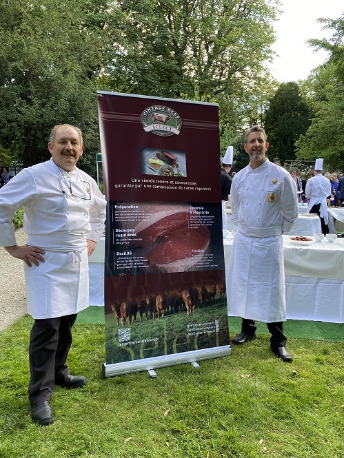 chefs standing near to a red meat banner